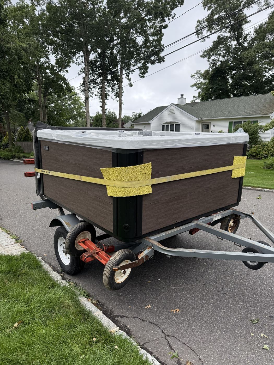Hot tub strapped and padded on our spa dolly trailer